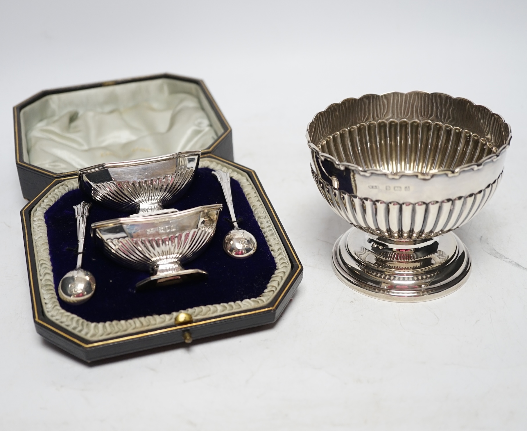An Edwardian small silver pedestal bowl, Birmingham, 1903, diameter 10.5cm and a cased pair of George V silver salts and spoons. Fair condition.